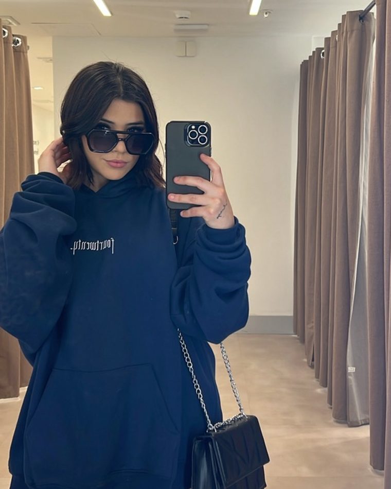 Adriana con sudadera azul en un probador