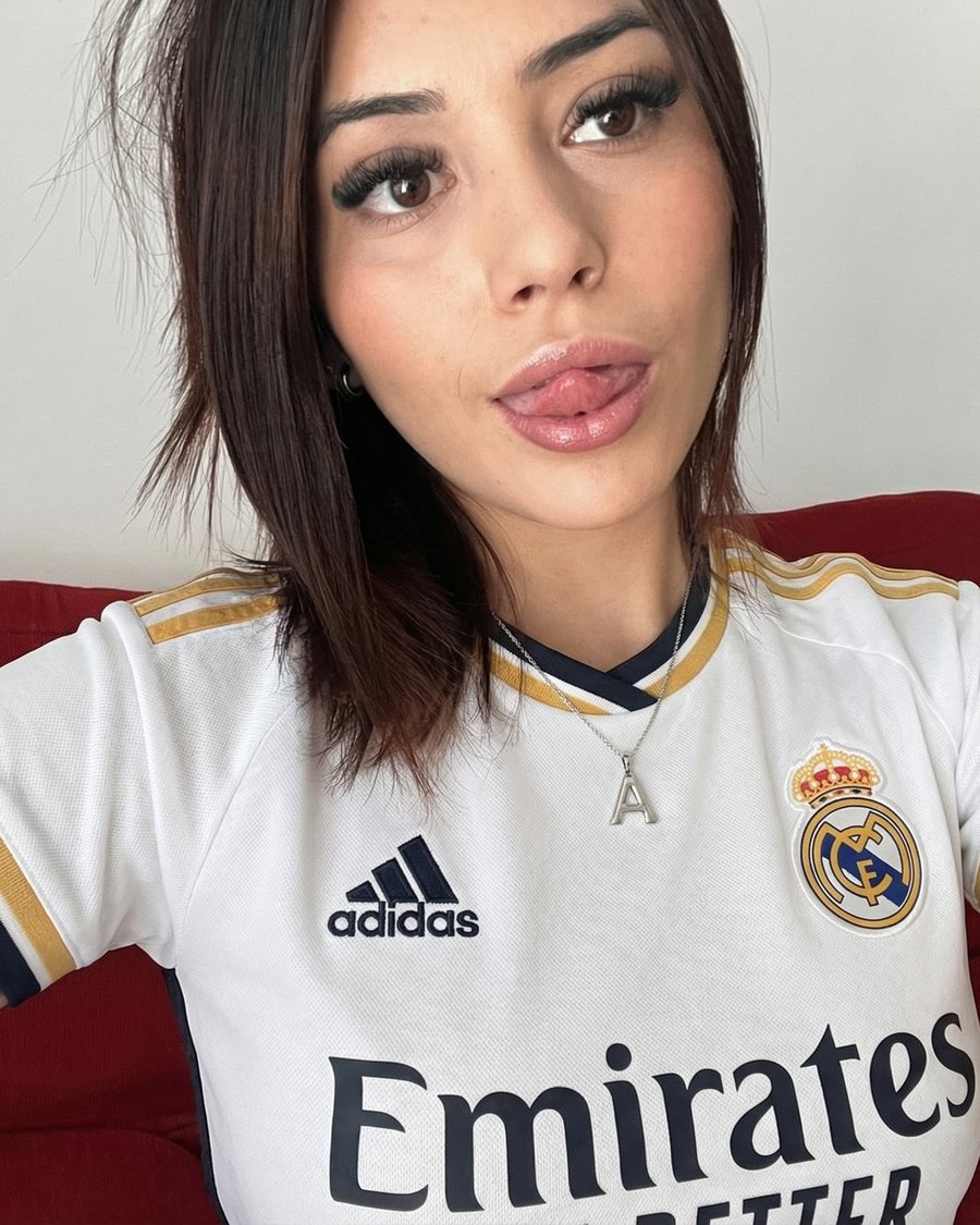 Adriana con la camiseta del equipo en el sofá rojo